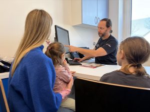 Arzt erklärt Familie Befund am Computer