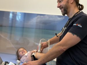 Arzt führt Ultraschalluntersuchung bei kleinem Kind durch